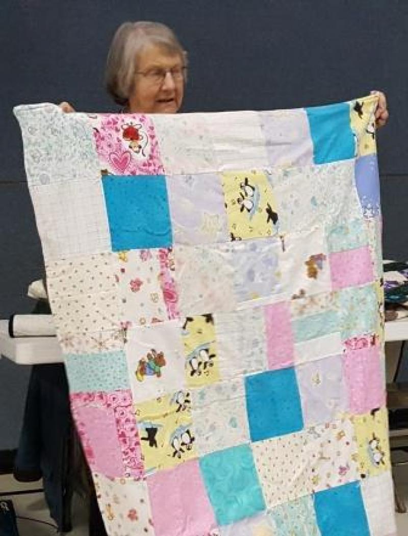 Eileen has gotten a baby quilt made.